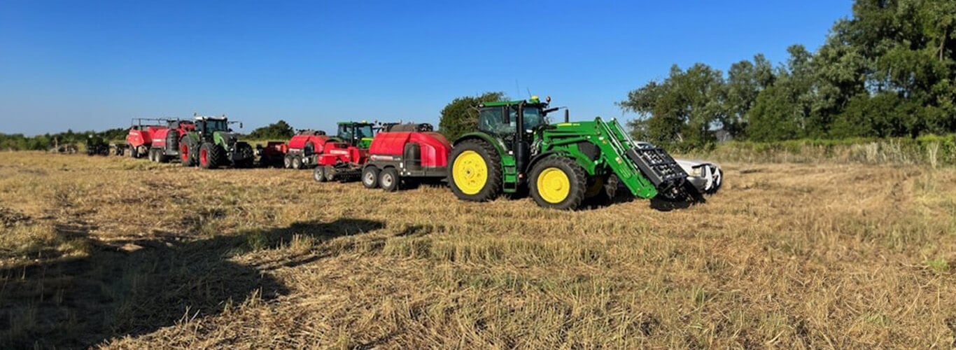 Several tractor with steamers and balers parked in field